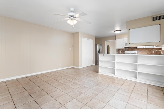 empty room with ceiling fan, sink, and light tile patterned flooring