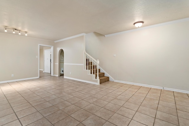 empty room with light tile patterned floors, a textured ceiling, and ornamental molding