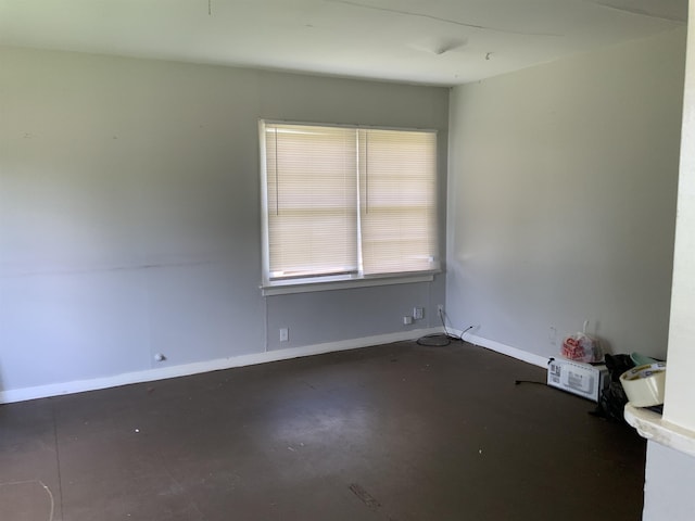 unfurnished room with concrete flooring and baseboards