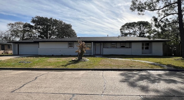 ranch-style home featuring a garage and a front lawn