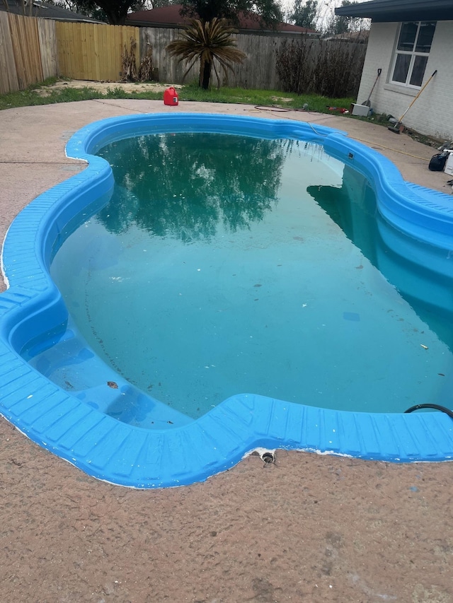 view of pool with a fenced backyard and a patio