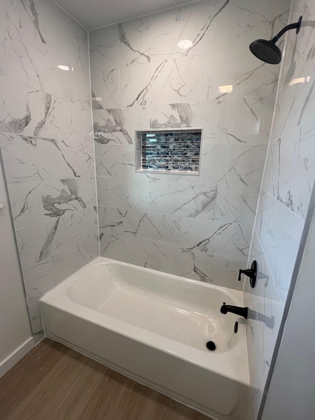 bathroom featuring hardwood / wood-style floors and tiled shower / bath combo