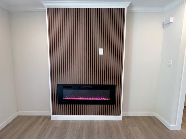 room details with a glass covered fireplace, wood finished floors, and crown molding