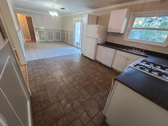 kitchen featuring white cabinetry, sink, an inviting chandelier, decorative light fixtures, and white appliances