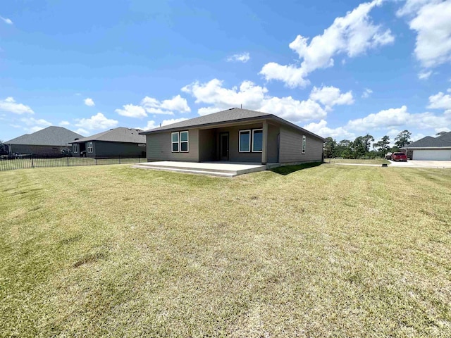 rear view of property with a patio area, fence, and a lawn