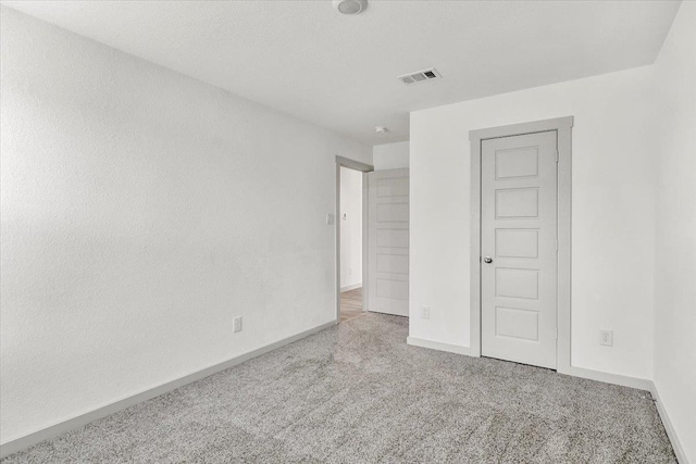 unfurnished bedroom with light colored carpet, visible vents, and baseboards