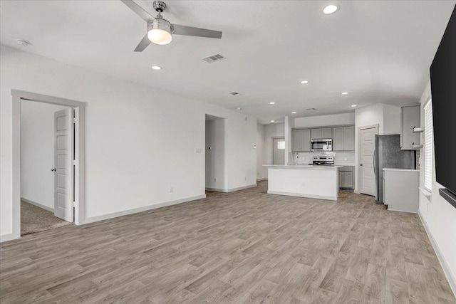 unfurnished living room with baseboards, visible vents, a ceiling fan, light wood-type flooring, and recessed lighting