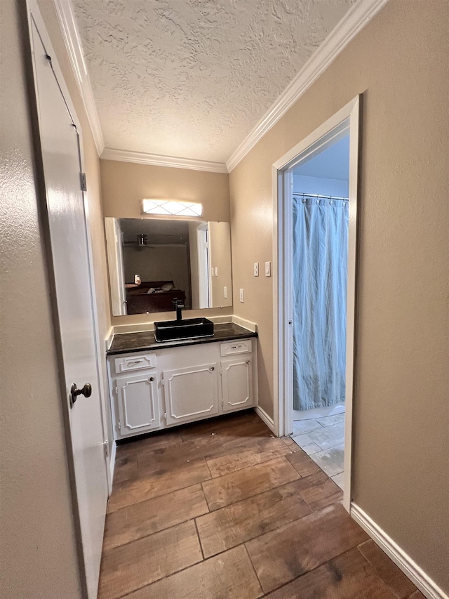 bathroom featuring vanity, a textured ceiling, and ornamental molding