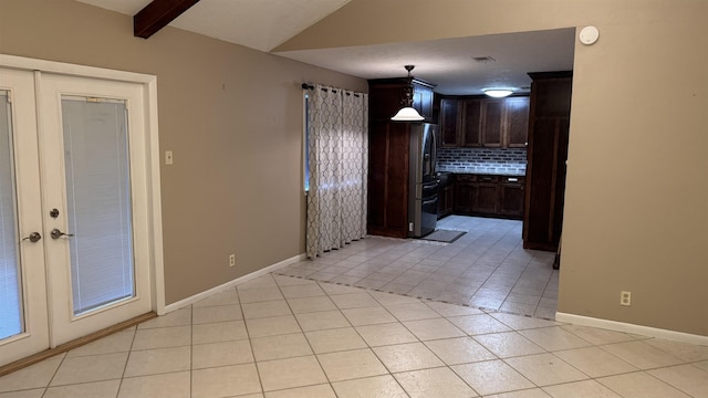 kitchen with hanging light fixtures, stainless steel fridge, decorative backsplash, dark brown cabinets, and light tile patterned floors