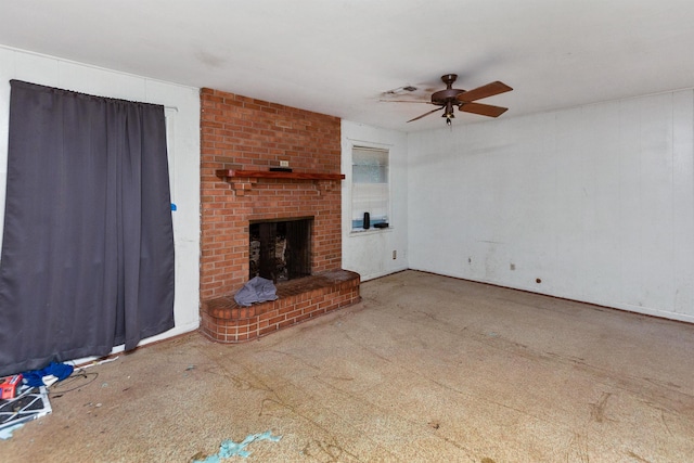 unfurnished living room featuring a brick fireplace and ceiling fan