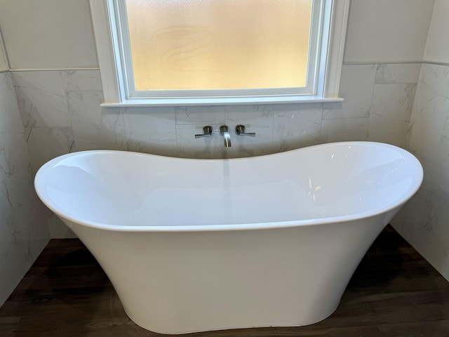 bathroom with a freestanding tub and tile walls