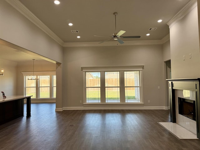unfurnished living room featuring dark wood-style floors, ceiling fan with notable chandelier, a high end fireplace, and ornamental molding