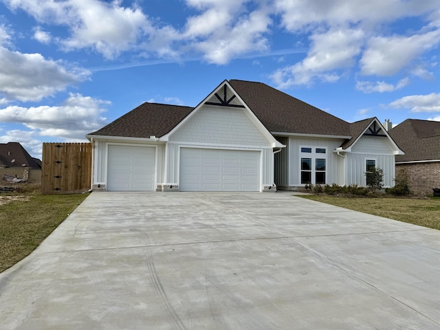 view of front facade featuring driveway, roof with shingles, a garage, and board and batten siding