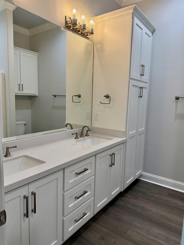 full bathroom with wood finished floors, crown molding, baseboards, and a sink