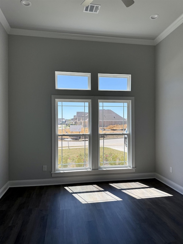 unfurnished room featuring baseboards, dark wood-style floors, visible vents, and ornamental molding