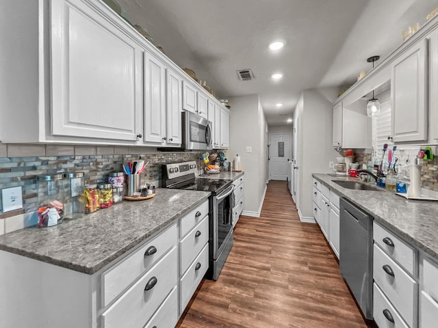 kitchen featuring hanging light fixtures, white cabinetry, sink, and stainless steel appliances