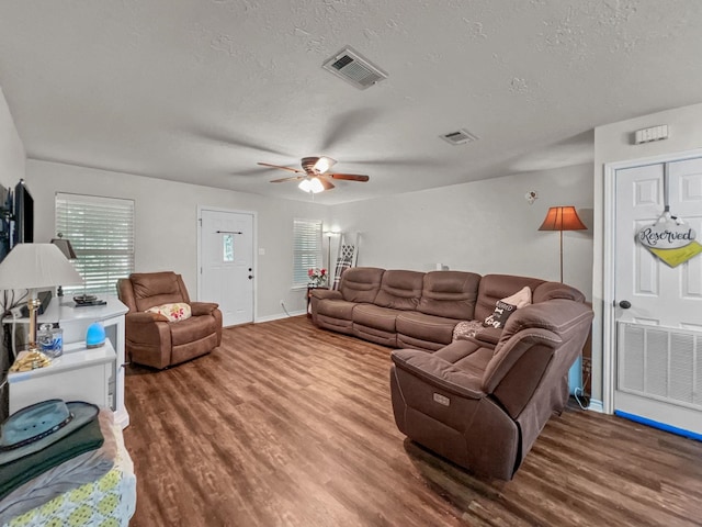 living room featuring ceiling fan, a textured ceiling, and hardwood / wood-style flooring