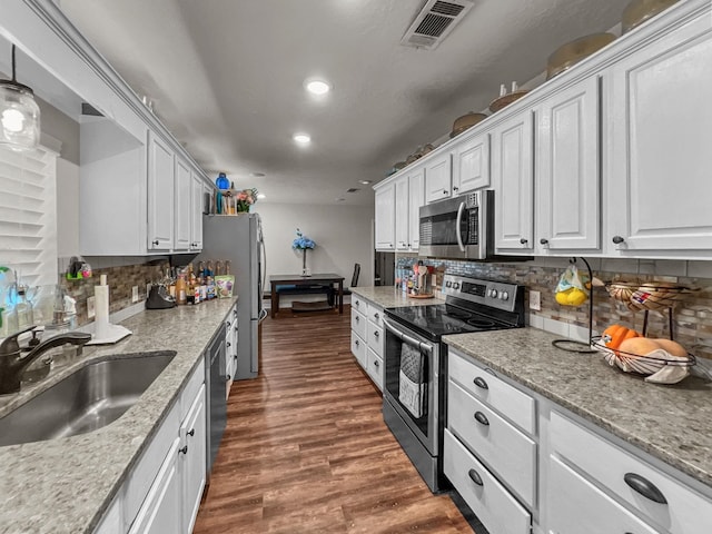 kitchen with backsplash, white cabinetry, sink, and appliances with stainless steel finishes