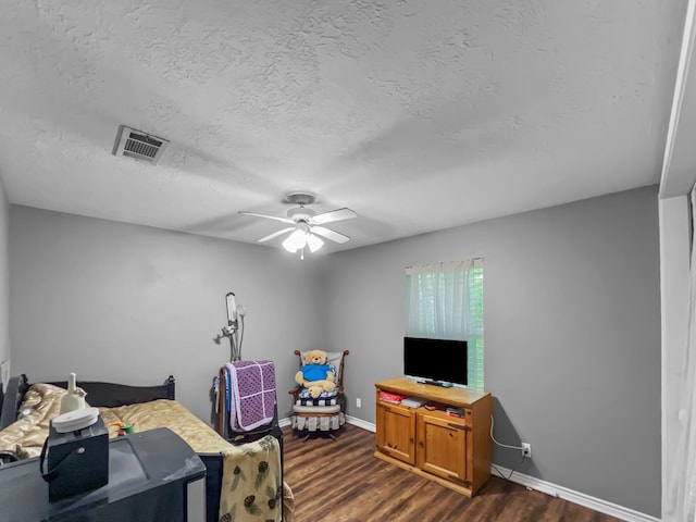 interior space with a textured ceiling, ceiling fan, and dark wood-type flooring