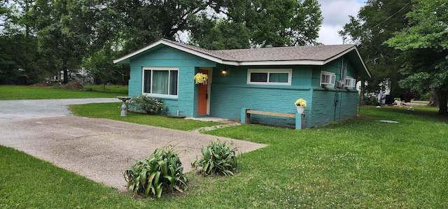 view of front of home with driveway and a front lawn
