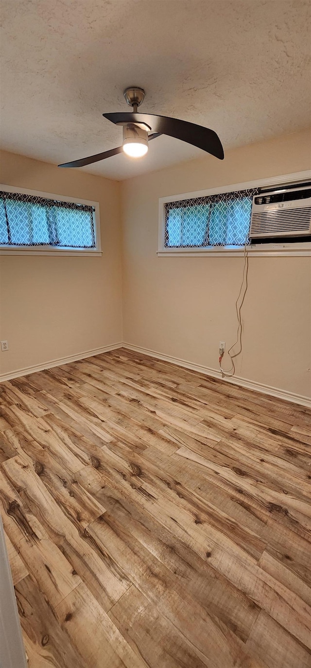 spare room with baseboards, a ceiling fan, and wood finished floors