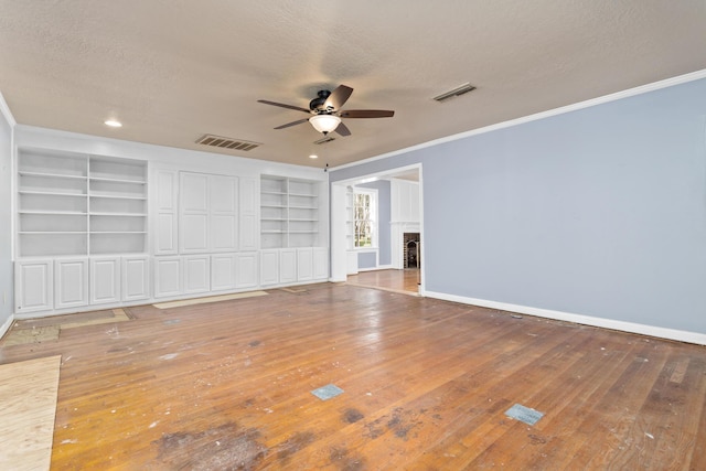 spare room featuring visible vents, baseboards, a textured ceiling, and a fireplace