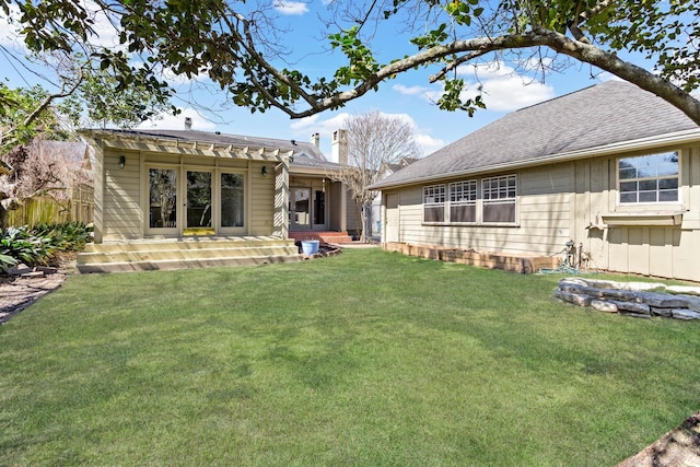 rear view of property featuring a yard, board and batten siding, a shingled roof, and fence