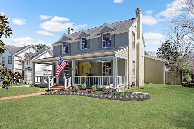 view of front of home with a porch, a chimney, a front lawn, and a ceiling fan