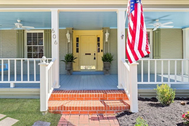 property entrance with a porch, brick siding, and ceiling fan