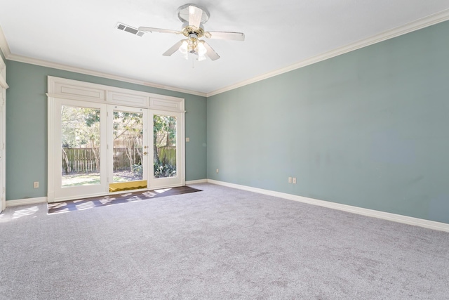 spare room with visible vents, ornamental molding, a ceiling fan, carpet floors, and baseboards