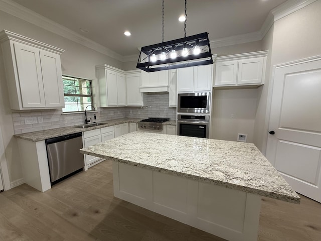 7735 Windcastle Dr, Beaumont, TX 77713 - kitchen with stainless steel appliances, white cabinets, a kitchen island, backsplash, and ornamental molding