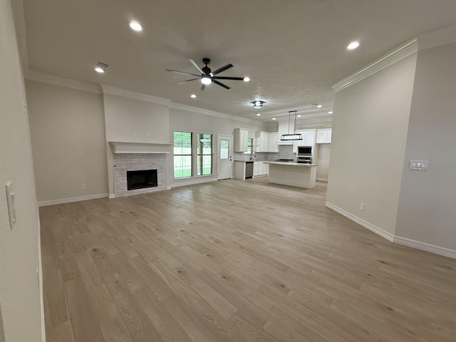 7735 Windcastle Dr, Beaumont, TX 77713 - unfurnished living room with ornamental molding, a ceiling fan, recessed lighting, light wood-style floors, and a fireplace