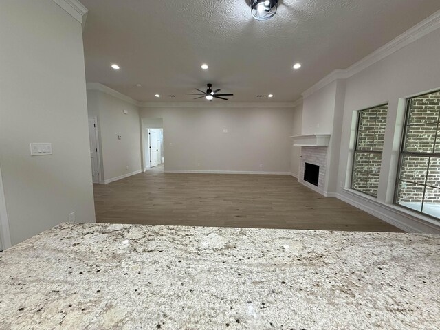 7735 Windcastle Dr, Beaumont, TX 77713 - unfurnished living room with wood finished floors, ornamental molding, ceiling fan, a fireplace, and recessed lighting