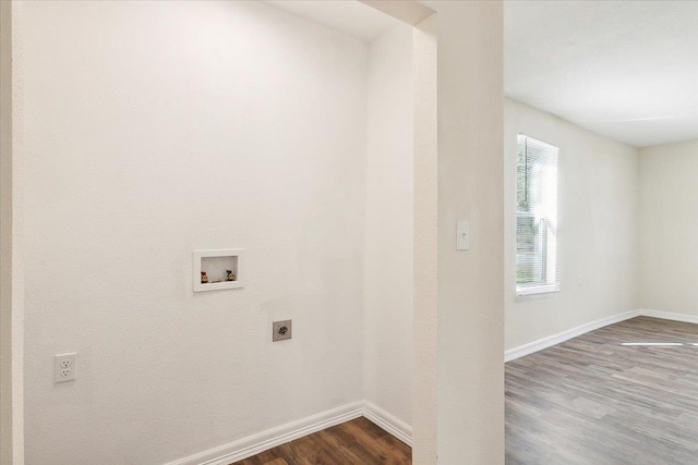 clothes washing area with hookup for an electric dryer, hookup for a washing machine, hardwood / wood-style flooring, and a healthy amount of sunlight