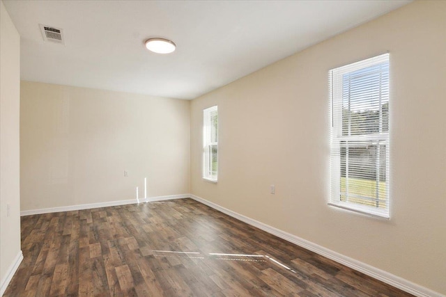 spare room featuring dark hardwood / wood-style floors and a wealth of natural light