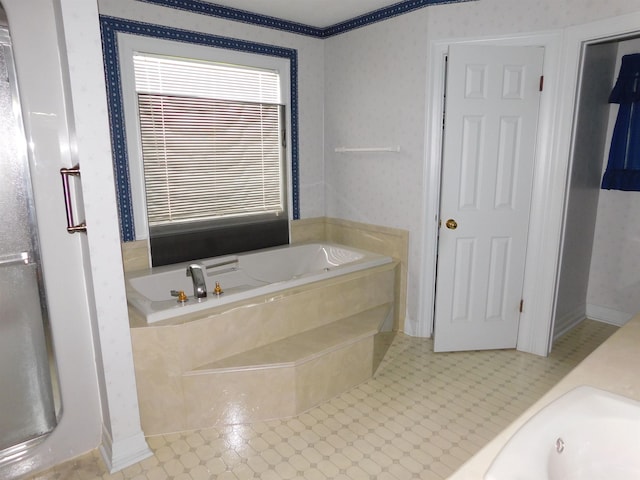 6340 Capitol St, Groves, TX 77619 - bathroom with a garden tub, wallpapered walls, and tile patterned flooring