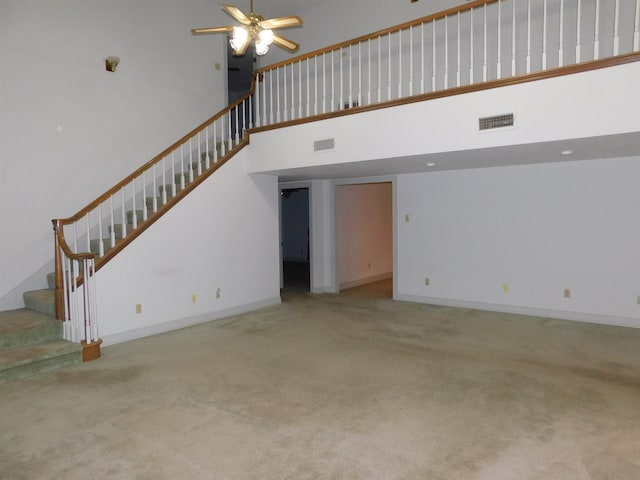 6340 Capitol St, Groves, TX 77619 - unfurnished living room featuring a high ceiling, stairway, carpet floors, and ceiling fan