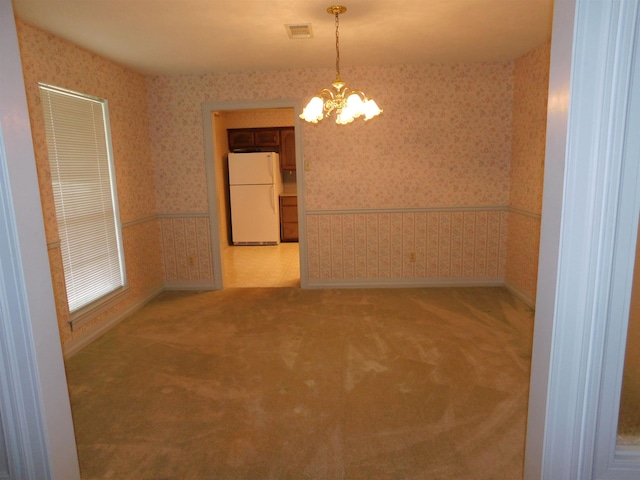 6340 Capitol St, Groves, TX 77619 - empty room with wallpapered walls, a chandelier, and carpet flooring