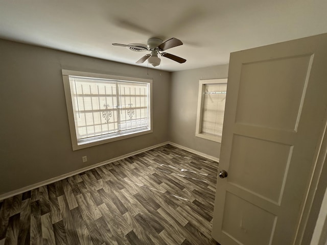 spare room featuring ceiling fan and dark wood-type flooring