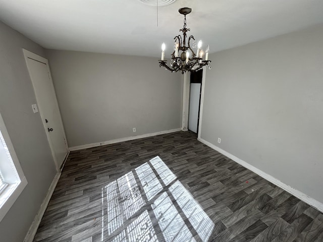 unfurnished dining area featuring dark wood-type flooring and an inviting chandelier