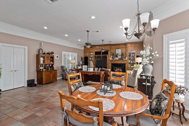 dining space featuring a wealth of natural light, ceiling fan with notable chandelier, and ornamental molding