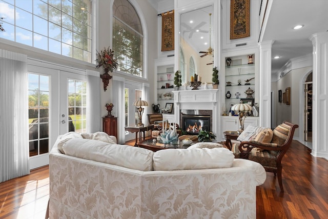 living room featuring hardwood / wood-style flooring, ornamental molding, a high ceiling, and french doors