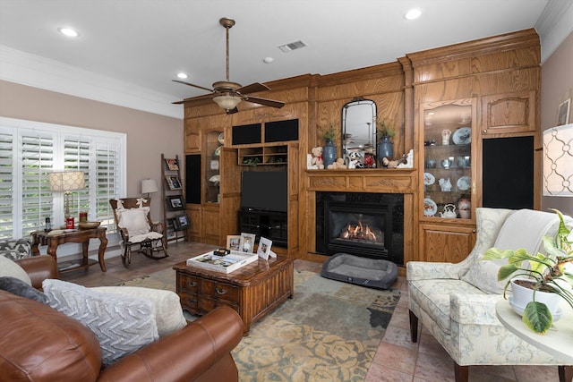 tiled living room featuring ceiling fan and ornamental molding