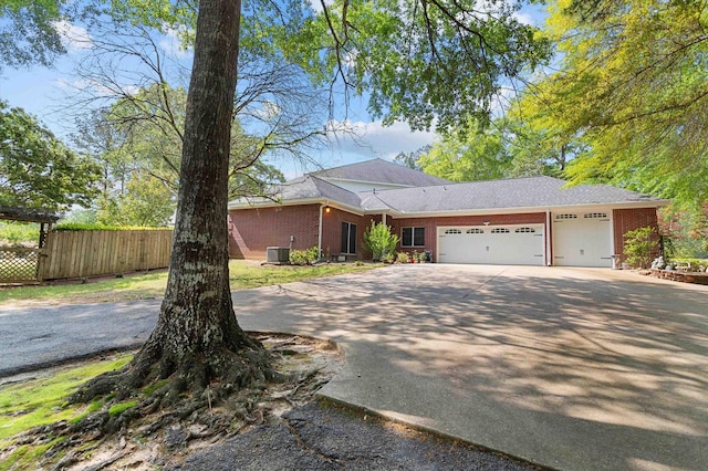 ranch-style home featuring central AC and a garage