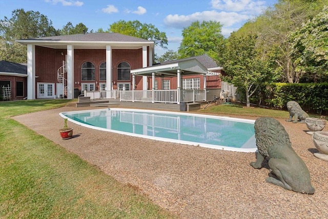 view of pool with a deck and a yard