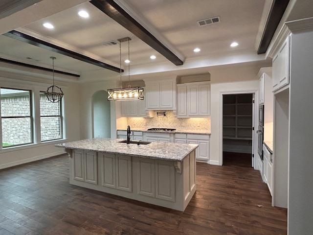 kitchen with dark wood-type flooring, visible vents, and a notable chandelier