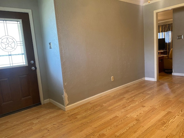  - foyer featuring light wood-style floors, baseboards, and a textured wall