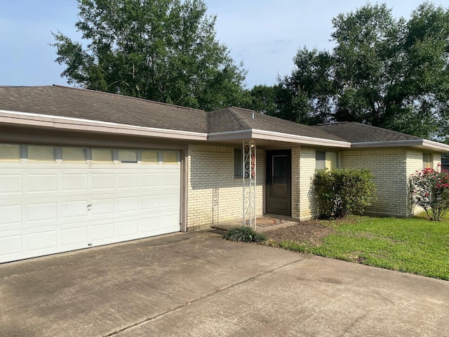  - single story home with concrete driveway, brick siding, an attached garage, and a shingled roof