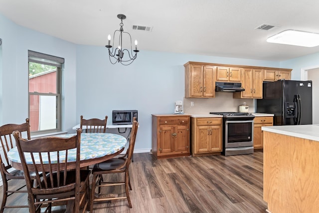 7714 N Linscomb Rd, Vidor, TX 77662 - kitchen featuring black fridge with ice dispenser, dark wood-style floors, light countertops, under cabinet range hood, and gas stove