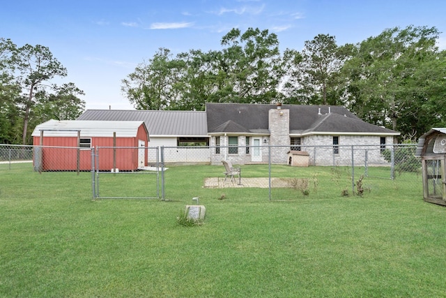7714 N Linscomb Rd, Vidor, TX 77662 - back of house with fence, a yard, a chimney, metal roof, and an outbuilding